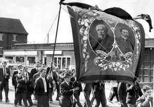 Prints of Durham Miners Gala - The Easington miners lodge banner, draped in black arrives back in the village after being carried at Durham Miners Gala 0000to0099 Prints: Durham Miners Gala Print - Easington Banner Returns Home