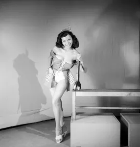 00064 Prints: 1959 Print of Woman in Fancy Dress Holding Large Spanner
