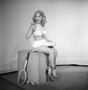 Retro Underwear Styles Prints: Anyone for tennis? Woman wearing bra, skirt holding tennis racket. 1959