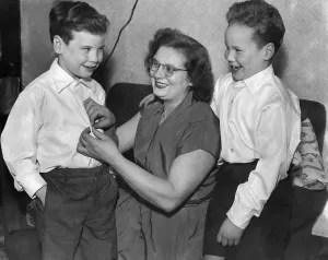 Black and white print of a mother and two sons in casual attire