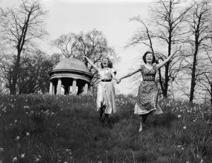 00090 Prints: Two Girls Running on a Spring Hill Print, England 1954
