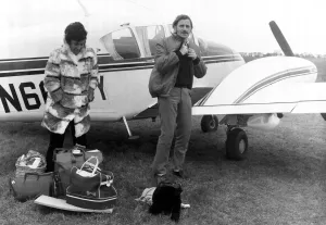 Graham Hill Prints: Graham Hill and Bette beside Crashed Plane Print 1975