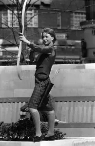 Prints of Fashions taken during London Fashion Week 1964 A women with a bow and arrow - archery - in the street London Fashion Week Prints: London Fashion Week 1964 Print: A Woman with a Bow