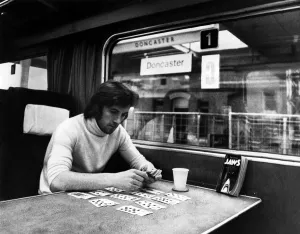 Prints of Footballer Stan Bowles, the man who doesn t like planes, settles down to a lonely game of cards on the way back from Newcastle. January 1976 P003866 0200to0299 Prints: Stan Bowles Print: A Lonely Game of Cards, January 1976