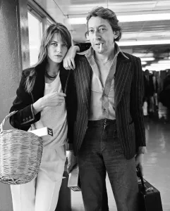 Prints of Serge Gainsbourg French composer and musician Serge Gainsbourg arriving at Heathrow Airport from paris with his wife English actress Jane Birkin. 25th April 1977 Transport Prints: Serge Gainsbourg at Heathrow Airport Print, 25th April 1977