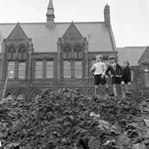 Prints of Pupils of Ross Place School, Ardwick, Manchester, jump across a sea of mud to enter school. December 1970 Greater Manchester Prints: Ross Place School Pupils Jumping Mud 1970 Print