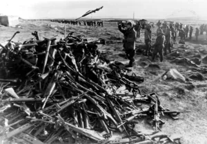 Prints of ARGENTINE SOLDIERS THROWING THEIR WEAPONS ONTO A PILE AT PORT STANLEY AFTER SURRENDERING TO THE BRITISH TASK FORCE DURING THE FALKLANDS WAR - 1982 1500to1599 Prints: Argentine Soldiers Surrender Print - Port Stanley 1982