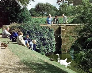 The moated manor house Baddesley Clinton, Warwickshire. Visitors with swans The moated manor house Baddesley Clinton, Warwickshire. Visitors with swans