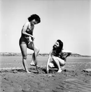 Models wearing the latest beachwear fashions digging. October 1952 C5081-001 Models wearing the latest beachwear fashions digging. October 1952 C5081-001