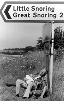 Images Dated 10th August 1977: Morris Codling snoozes with his grandson under a signpost in Norfolk