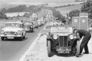 Mortorist seen here trying to repair his MG as heavy August Bank Holiday traffic Mortorist seen here trying to repair his MG as heavy August Bank Holiday traffic