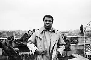 Images Dated 12th December 1980: Muhammad Ali, former heavyweight boxing champion, stepping outside into the rain after a