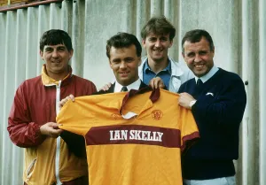 New Motherwell signing Davie Cooper poses with the team shirt as he stand with management New Motherwell signing Davie Cooper poses with the team shirt as he stand with management