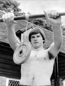Nick Faldo Golf stands bare chested as he exercises his wrists by holding a weight Nick Faldo Golf stands bare chested as he exercises his wrists by holding a weight