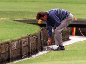 Nick Faldo retrieves his ball from the Swilken burn at the 1st after putting his ball in Nick Faldo retrieves his ball from the Swilken burn at the 1st after putting his ball in
