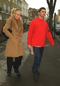 Noel Gallagher of Oasis holding a copy of the Daily Mirror newspaper with his girlfriend Noel Gallagher of Oasis holding a copy of the Daily Mirror newspaper with his girlfriend