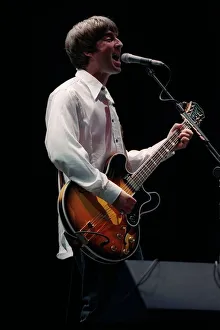 Noel Gallagher of the pop group Oasis on stage singing and playing guitar at Loch Lomond Noel Gallagher of the pop group Oasis on stage singing and playing guitar at Loch Lomond