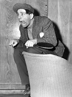 NORMAN WISDOM ACTS AS A JOCKEY ON HIS DRESSING ROOM SEAT, LONDON PALLADIUM - MAY 1954 NORMAN WISDOM ACTS AS A JOCKEY ON HIS DRESSING ROOM SEAT, LONDON PALLADIUM - MAY 1954
