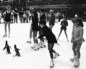 Two penguins, pretending not to notice all the other ice skaters are quite unconcerned by Two penguins, pretending not to notice all the other ice skaters are quite unconcerned by