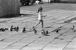 Pier Head, Liverpool, Merseyside, 17th August 1988. Young child plays with pigeons Pier Head, Liverpool, Merseyside, 17th August 1988. Young child plays with pigeons