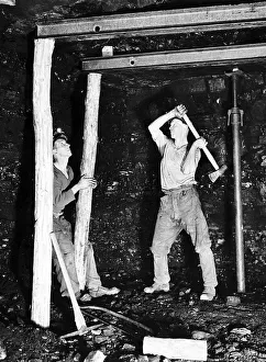 Pitprops being hammered into position under the steel roof supports at Whitehill Colliery Pitprops being hammered into position under the steel roof supports at Whitehill Colliery