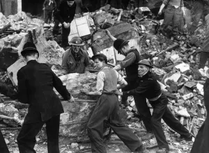 Policeman in short sleeves helmet frantically trying to move a giant rock in the wreckage Policeman in short sleeves helmet frantically trying to move a giant rock in the wreckage