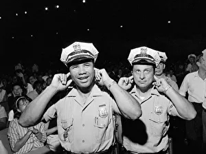 Two policemen try to block out the noise of the band playing Two policemen try to block out the noise of the band playing