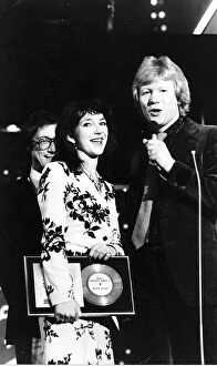 Images Dated 11th April 1979: Pop singer Kate Bushholds her award as she stands with Radio 1 Disc Jockey David Kid