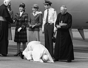 Pope John Paul II kneels down and kisses the ground at Cardiff airport on his visit to Pope John Paul II kneels down and kisses the ground at Cardiff airport on his visit to