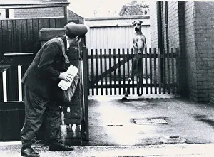 A Postman hides behind a wall scared of a Great Dane dog leaning on fence Dogs A Postman hides behind a wall scared of a Great Dane dog leaning on fence Dogs