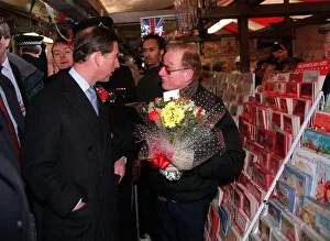 Prince Charles looks at Valentine cards at Dudley market while police officers in Prince Charles looks at Valentine cards at Dudley market while police officers in