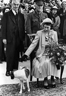 Princess Elizabeth II at Sark receiving a bouquet of flowers Dog at feet looking Princess Elizabeth II at Sark receiving a bouquet of flowers Dog at feet looking