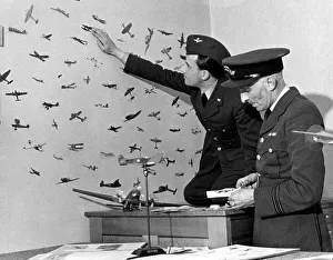 An RAF officer preparing cut outs of enemy planes from magazines to stick on the walls of An RAF officer preparing cut outs of enemy planes from magazines to stick on the walls of