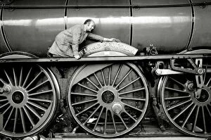 Images Dated 24th June 1987: Railway worker cleans the sign on the wheels on the Flying Scotsman steam train
