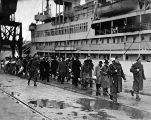 Refugees from Dutch colonies marching along the quayside under Dutch soldier escort Refugees from Dutch colonies marching along the quayside under Dutch soldier escort