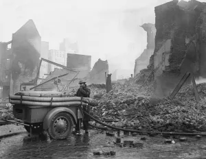 A rescue worker operating a Coventry Climax fire pump admist the shroud of smoke A rescue worker operating a Coventry Climax fire pump admist the shroud of smoke