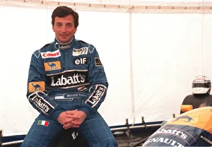 RICARDO PATRESE, MOTOR RACING DRIVER, AT SILVERSTONE SITTING BESIDE CAR WEARING RACING RICARDO PATRESE, MOTOR RACING DRIVER, AT SILVERSTONE SITTING BESIDE CAR WEARING RACING