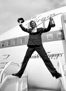 Richard Branson holding a bottle of champagne and pilots hat as he celebrates Virgin Richard Branson holding a bottle of champagne and pilots hat as he celebrates Virgin