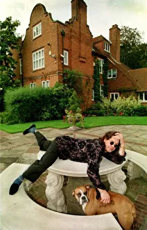 Rock star Ozzy Osbourne at home Lying on a stone table with one of their pet dogs Rock star Ozzy Osbourne at home Lying on a stone table with one of their pet dogs