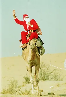 Santa Claus riding a camel holding sack. 1990 Santa Claus riding a camel holding sack. 1990