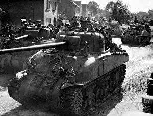 A Sherman Firefly 1C Tank of the 11th Armoured Division leads a column of tanks through A Sherman Firefly 1C Tank of the 11th Armoured Division leads a column of tanks through