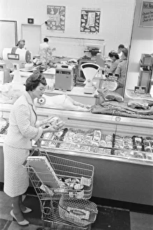 Shopper browsing the butchers counter at a newly opened self service food store in North Shopper browsing the butchers counter at a newly opened self service food store in North