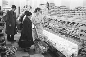 Shoppers browsing the dairy counter at a newly opened self service food store in North Shoppers browsing the dairy counter at a newly opened self service food store in North
