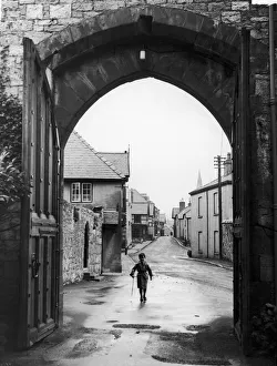 A small boy walks through the archway at the entrance of Ruthin Castle Denbighshire A small boy walks through the archway at the entrance of Ruthin Castle Denbighshire