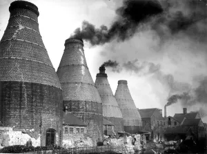 A smokey view with the typical scene of bottle ovens and kilns during the industrial A smokey view with the typical scene of bottle ovens and kilns during the industrial