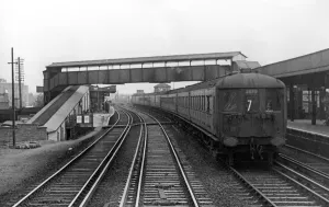 A Southern Railways main line electric train passing through Raynes Park. c A Southern Railways main line electric train passing through Raynes Park. c