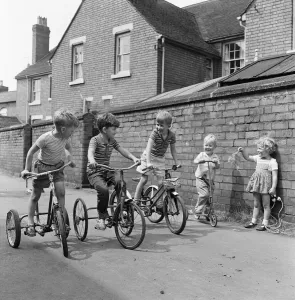 Under starters orders. Boys on their tricycles prepare to race in the back lanes of Under starters orders. Boys on their tricycles prepare to race in the back lanes of