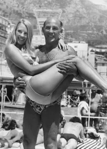 Stirling Moss carrying model Liz Hooley in Monaco - June 1973 04/06/1973 Stirling Moss carrying model Liz Hooley in Monaco - June 1973 04/06/1973