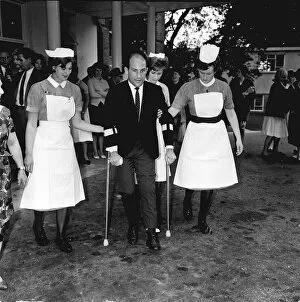 Images Dated 29th June 1999: Stirling Moss motor racing driver leaving hospital 1962 on crutches with help of
