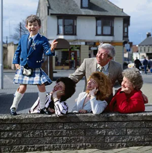 Stuart Anderson April 1989 child Andy Stewart impersonator standing on a wall watched by Stuart Anderson April 1989 child Andy Stewart impersonator standing on a wall watched by